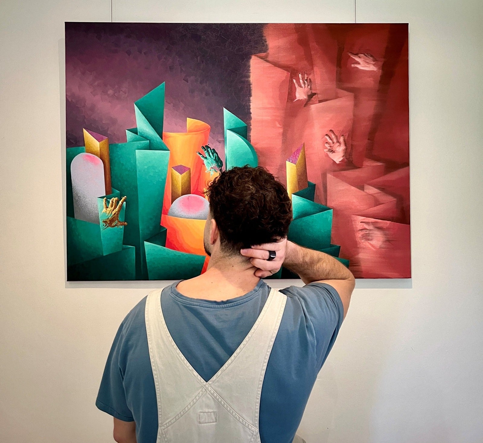 Person looking at a colorful abstract painting on a wall